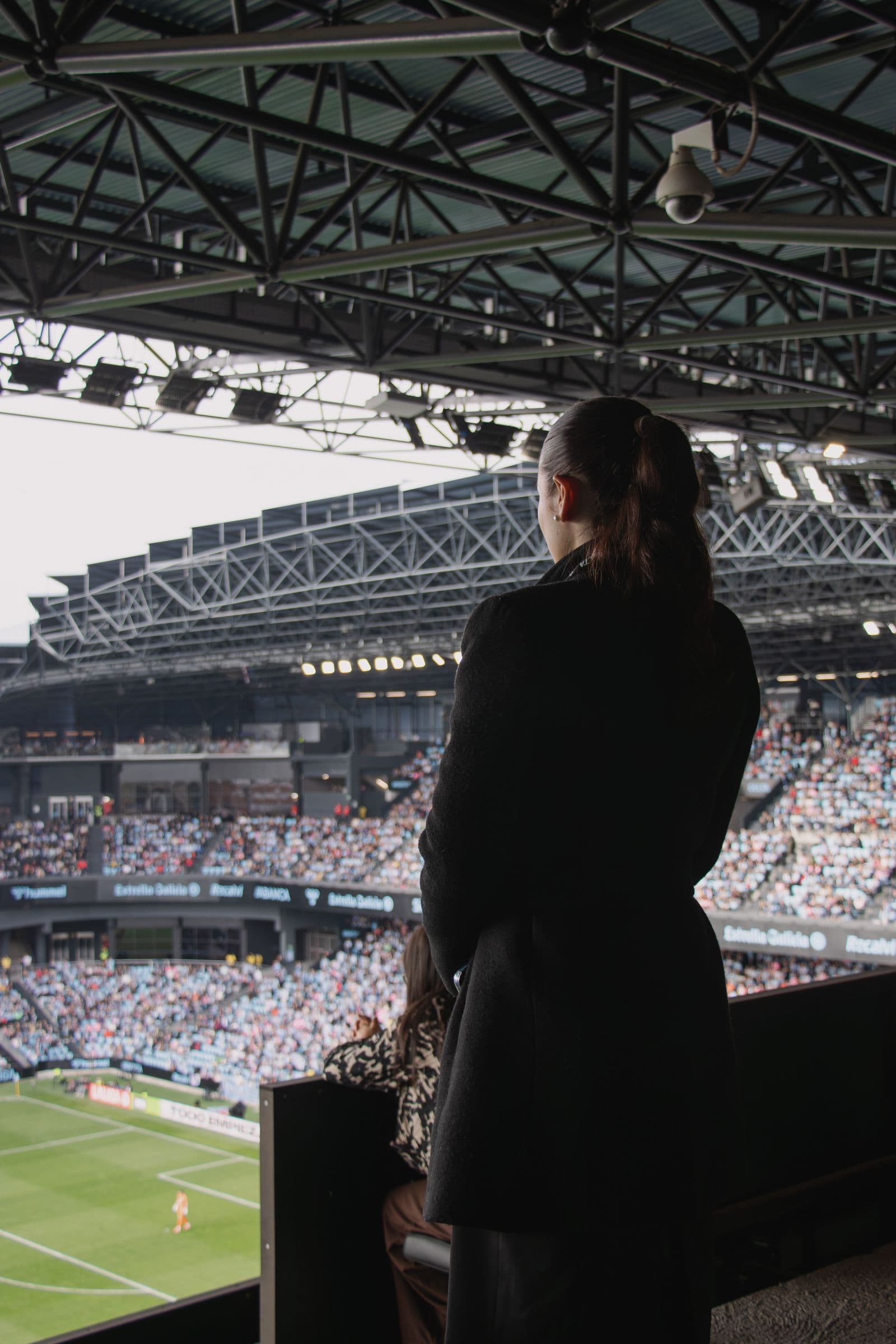 Azafata de Aptia observando desde lo alto la grada llena y el campo de Balaídos