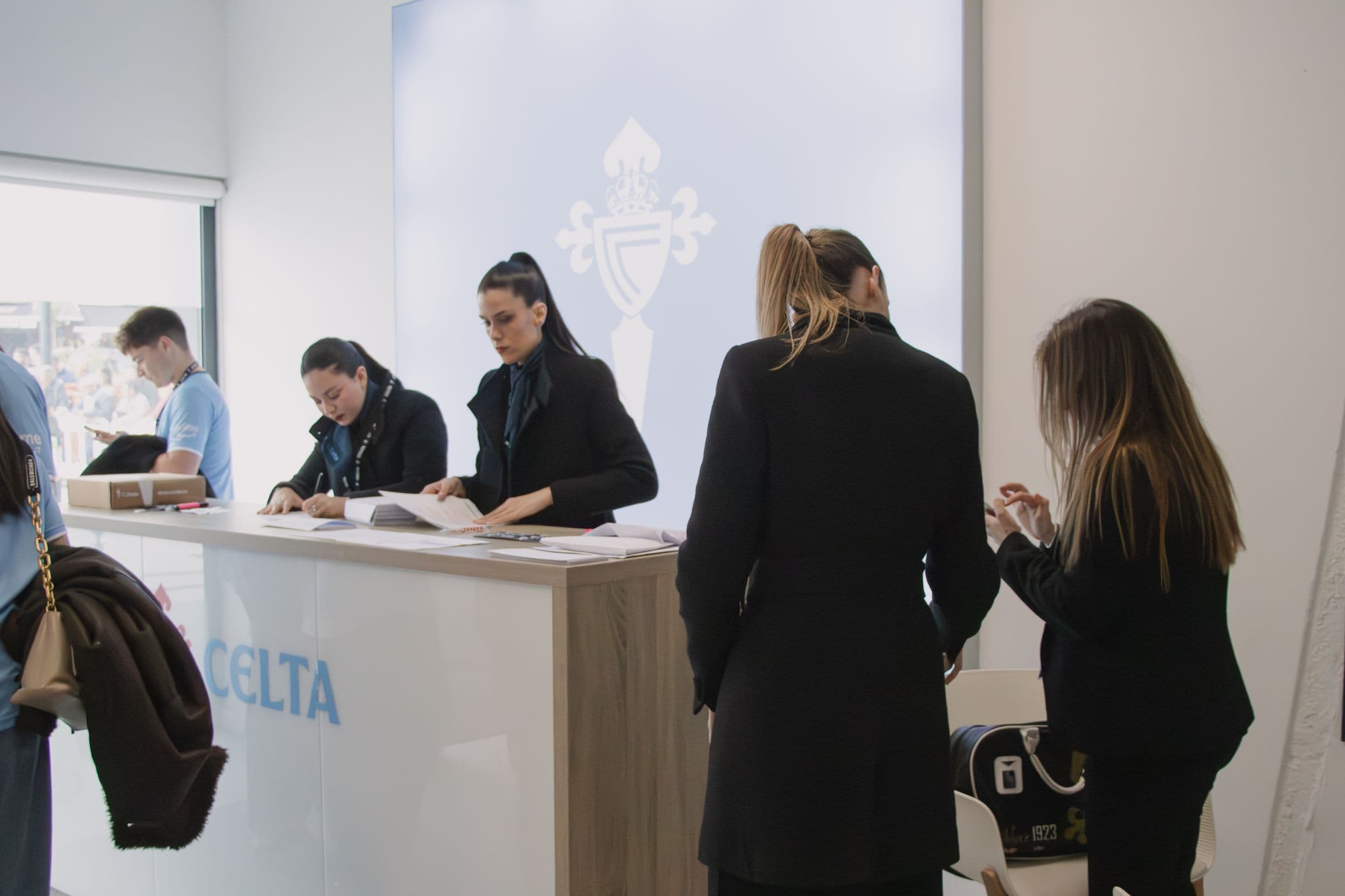 Azafatas de Aptia traballando no mostrador de acollida do Celta